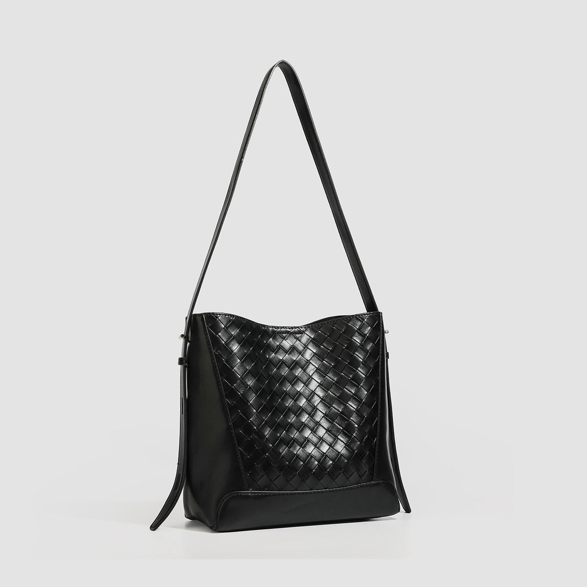 Large black bucket shoulder bag with diamond woven leather-look front panel, smooth side panels, magnetic snap closure, and