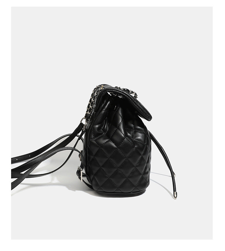 Black diamond-quilted backpack handbag with silver-tone chain flap accent and adjustable shoulder straps, detail view 13