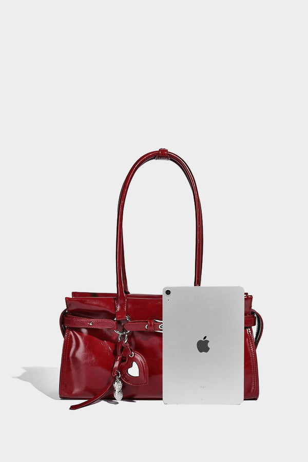 Structured rectangular glossy tote shoulder bag with belt buckle front strap and dangling charm hardware, detail view 16