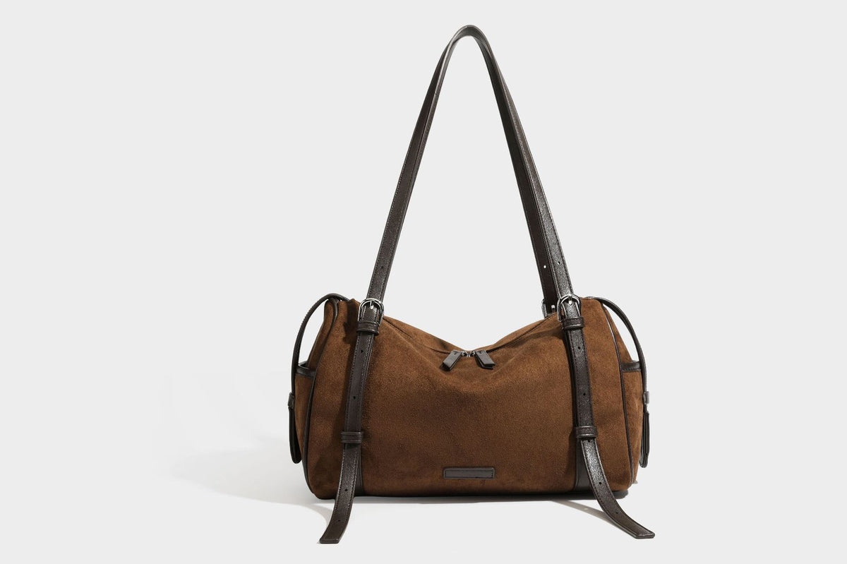 Large brown suede-finish barrel shoulder bag with dark leather-look trim, silver-tone zippers, dual top handles, and long