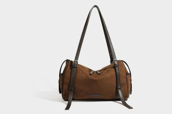 Large brown suede-finish barrel shoulder bag with dark leather-look trim, silver-tone zippers, dual top handles, and long