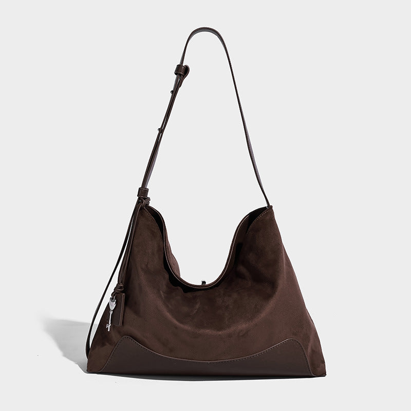 Dark brown slouchy hobo bag with matte suede-look body, smooth leather-look base trim, adjustable shoulder strap, and, detail