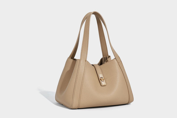 Structured trapezoid tote bag in taupe pebbled leather-look finish with gold-tone turn-lock hardware, dual top handles, and