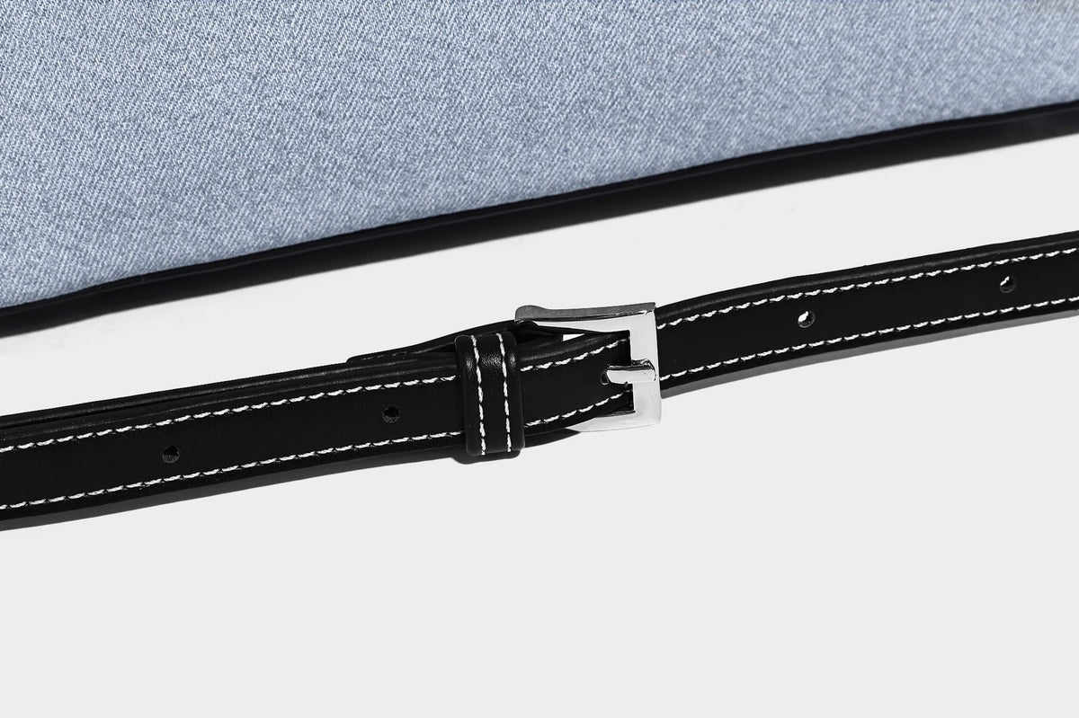 Compact structured satchel in light blue denim-look fabric with black leather-look trim, silver turn-lock closure, rolled