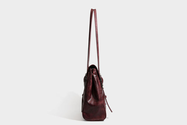 Structured flap-top shoulder tote bag in distressed leather-look finish with silver-tone buckle hardware and double shoulder