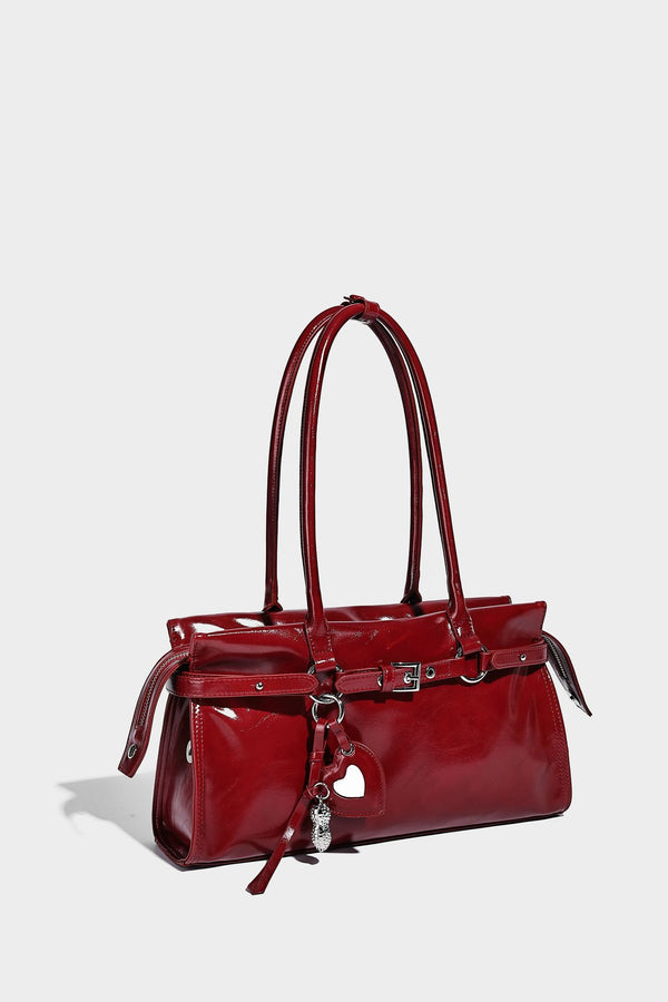 Structured rectangular glossy tote shoulder bag with belt buckle front strap and dangling charm hardware, detail view 22