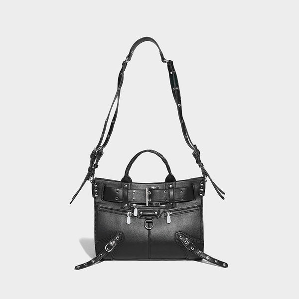 Black structured rectangular satchel bag with silver-tone rivets, large front buckle strap, zip pockets, dual top handles
