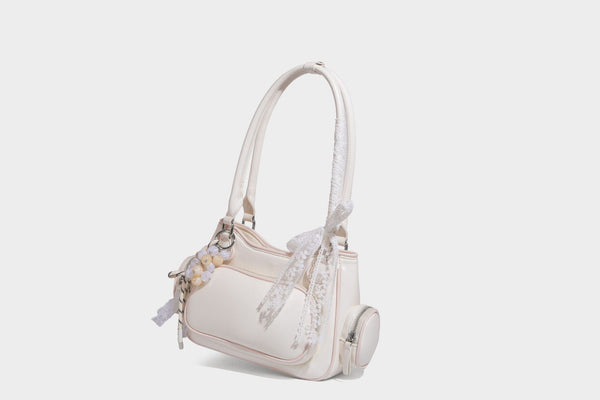 Kleine, formstabile Schultertasche mit glänzender Oberfläche, weißem Paspelbesatz, Spitzenschleife und rotem Perlenanhänger, Reißverschluss-Seitentaschen und silberfarbenem