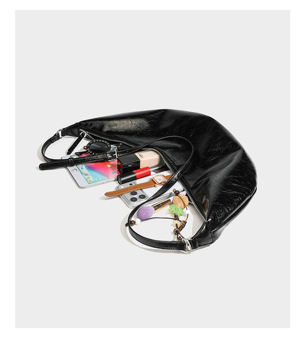 Lässig fallende Hobo-Schultertasche in Halbmondform mit glänzender, geknautschter Lederoptik, schmalem Riemen, silberfarbenen Ringbeschlägen und