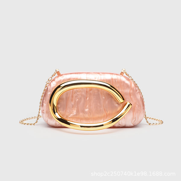Kleine rechteckige Crossbody-Clutch mit abgerundeten Ecken, oversized poliertem C-förmigem Goldgriff und schmalem Goldkettenriemen, Detailansicht