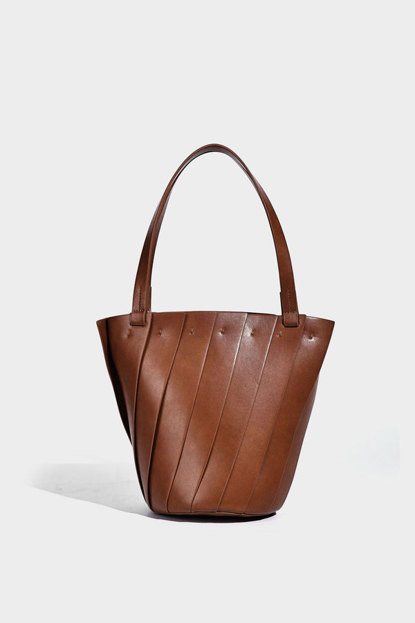 Structured bucket tote bag with vertical panel exterior, dual top handles, and detachable shoulder strap in tan leather-look