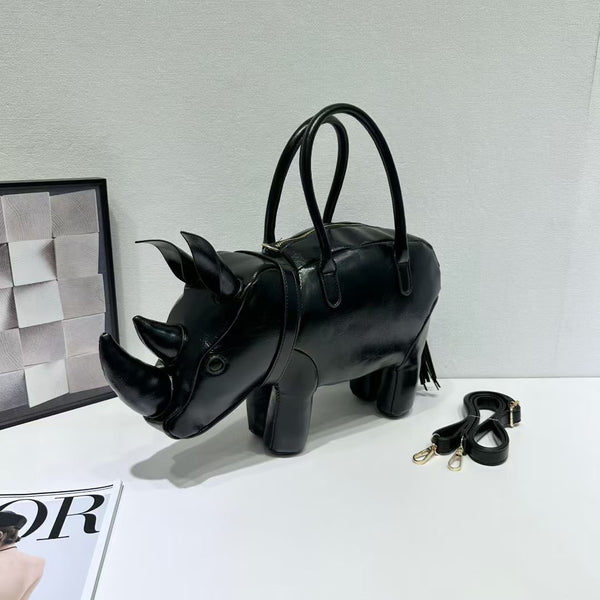 Rhinoceros-shaped 3D structured handbag with sculpted horns, four legs, tassel tail, twin top handles, and detachable, detail