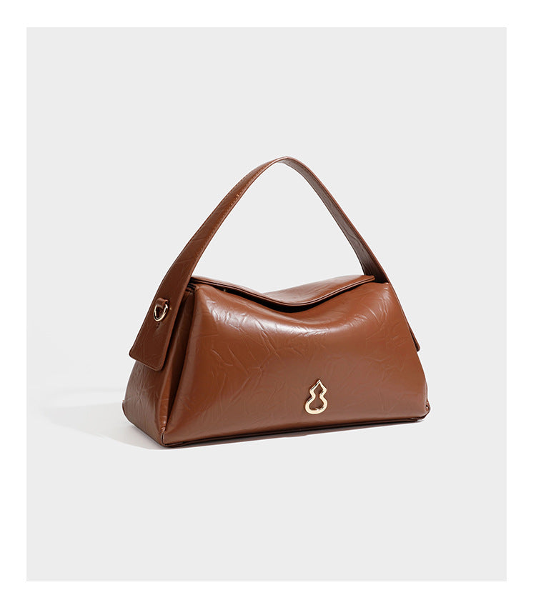Glänzende, geknautschte Trapez-Schultertasche mit Überschlagverschluss, goldfarbenen Logo-Beschlägen, Tragegriff und abnehmbarem, verstellbarem Schulterriemen