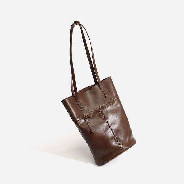 Large black smooth leather-look bucket tote bag with long shoulder straps and open top, detail view 2