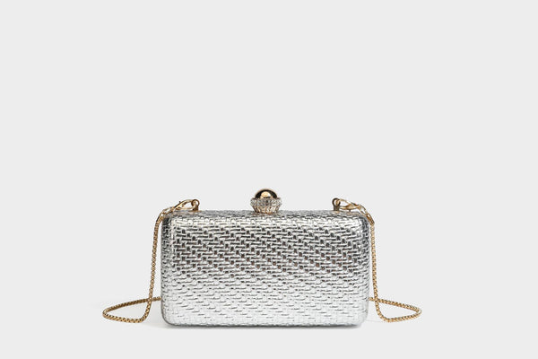 Small structured metallic woven-texture box clutch bag with jeweled kiss-lock dome clasp and slim gold chain strap, detail