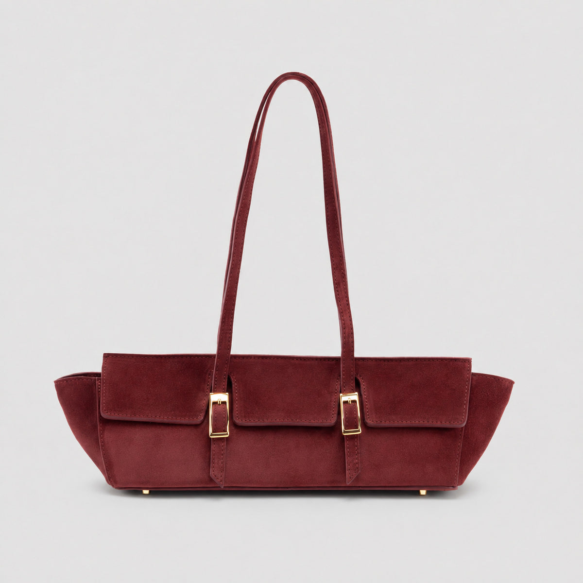 Wide trapezoid tote bag with matte suede-like finish, dual gold-tone buckle front pockets, and double flat shoulder straps