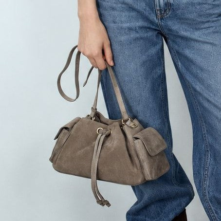 Weiche Beuteltasche mit Kordelzug in Taupe und Wildlederoptik, seitlichen Klappentaschen, antikgoldfarbenen Metalldetails und verstellbarem Crossbody-Riemen