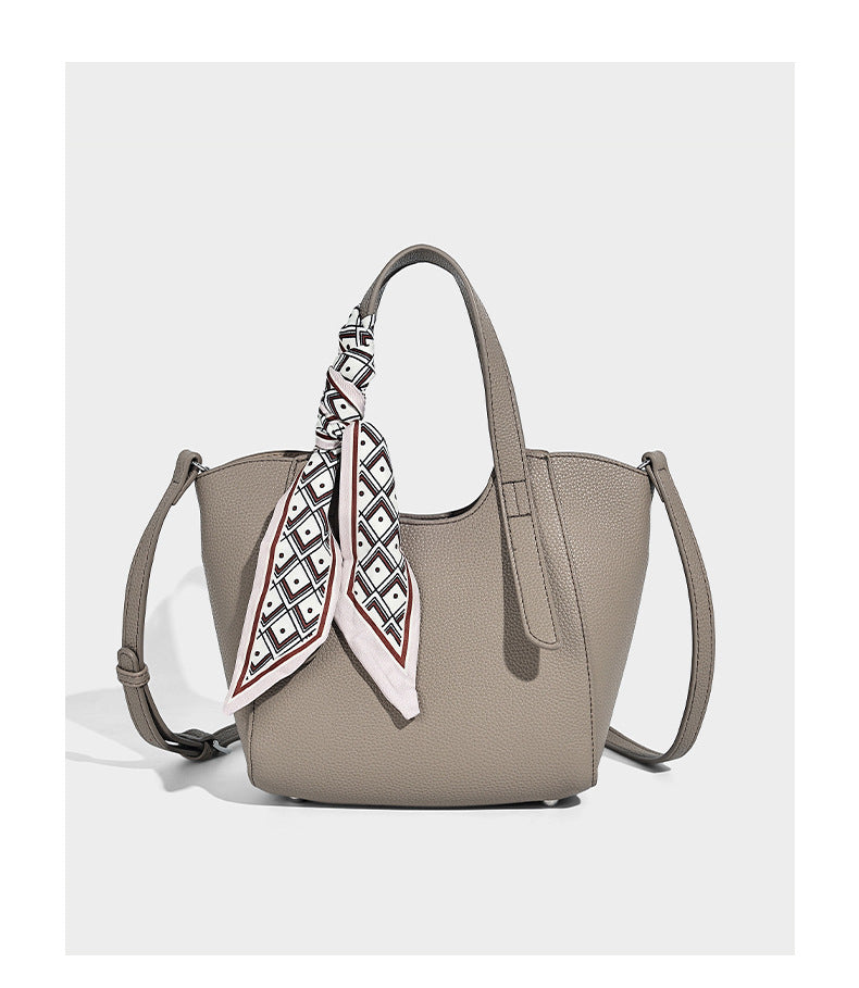 Structured pebbled leather-look tote bag with detachable scarf tie, dual top handles, and adjustable crossbody strap, detail