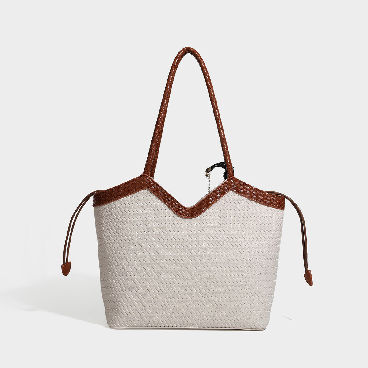 Woven tote bag with braided shoulder straps, drawstring closure, and dangling metal-and-bead charm, detail view 3