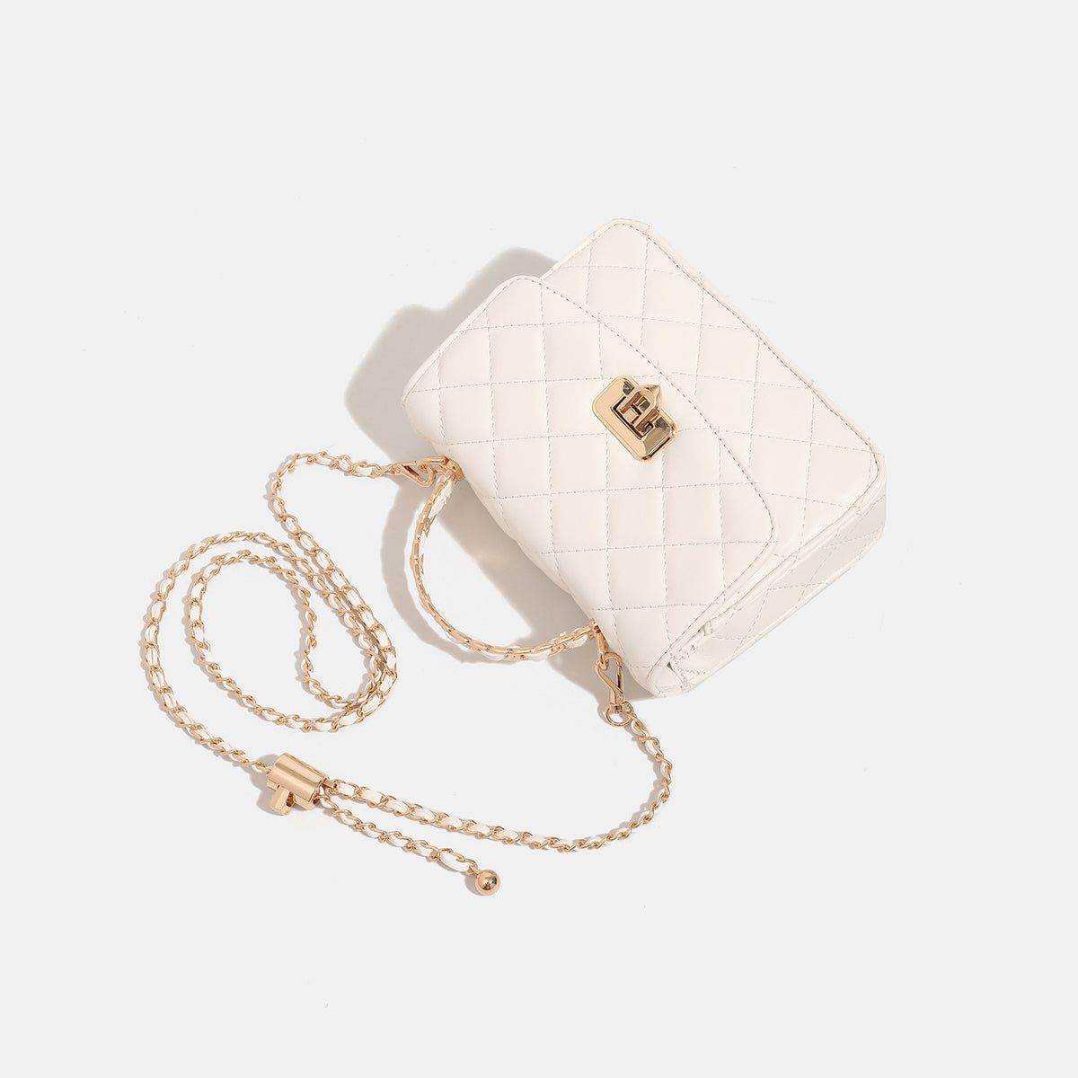Small structured quilted flap crossbody bag with gold-tone turn-lock closure and chain strap, detail view 4