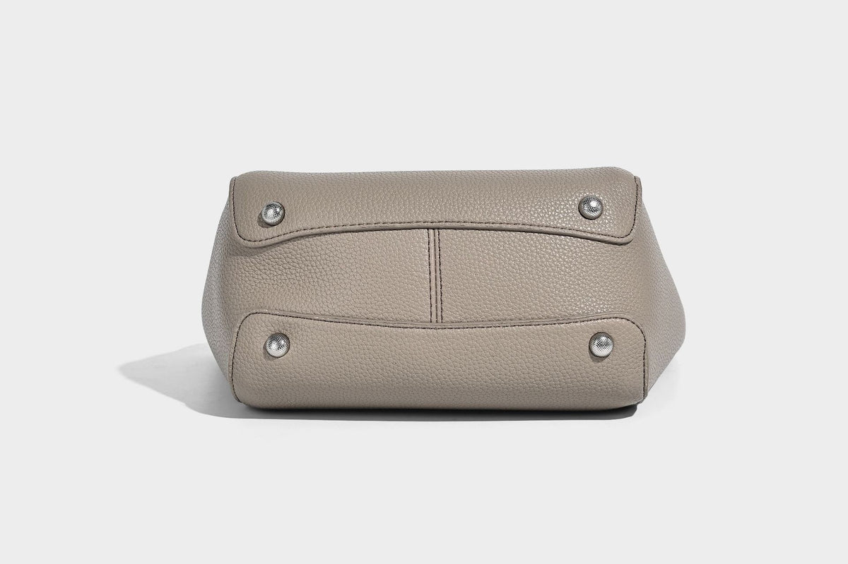 Structured pebbled leather-look tote bag with detachable scarf tie, dual top handles, and adjustable crossbody strap, detail