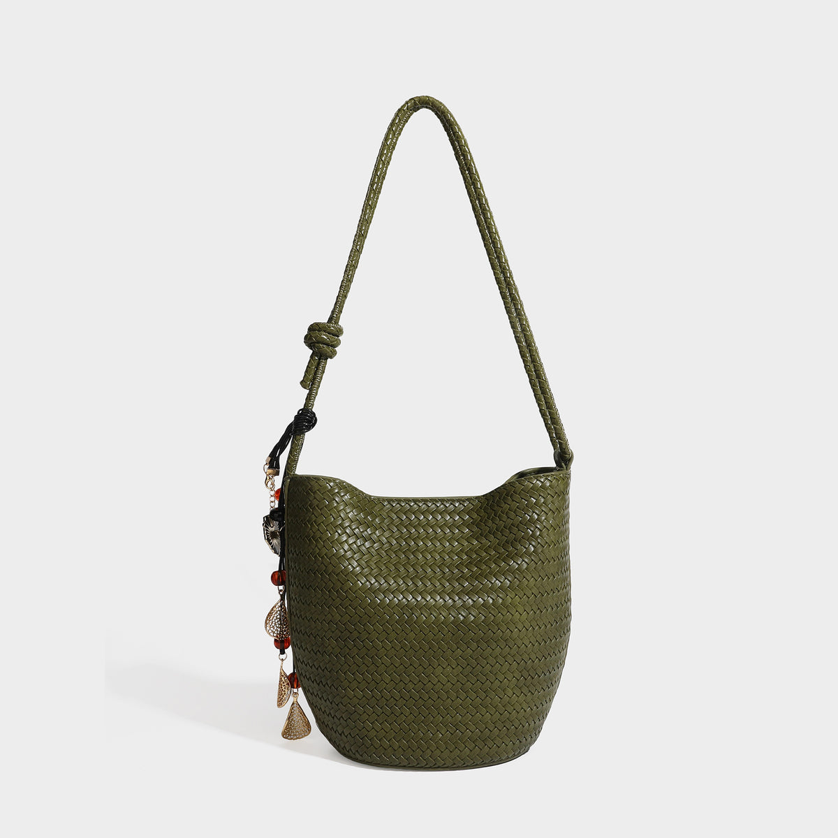 Olive green woven leather-look bucket bag with braided crossbody strap, knotted adjustment, and gold-tone tassel charm with