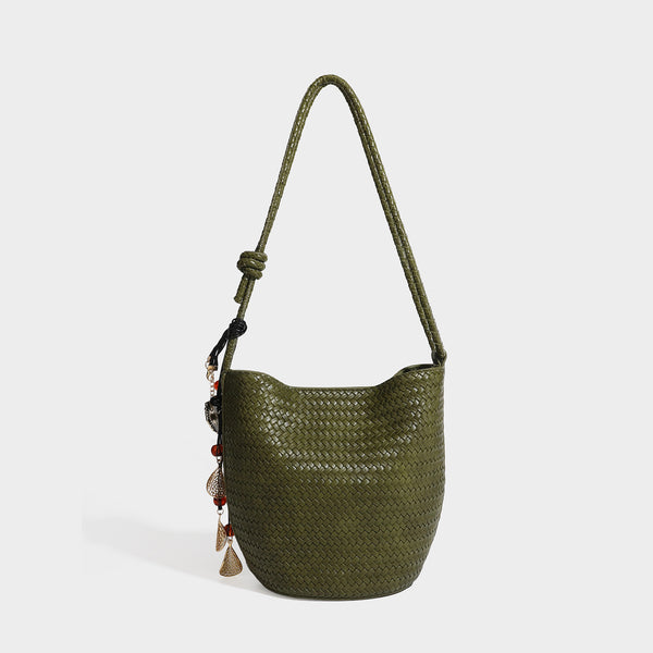 Olive green woven leather-look bucket bag with braided crossbody strap, knotted adjustment, and gold-tone tassel charm with
