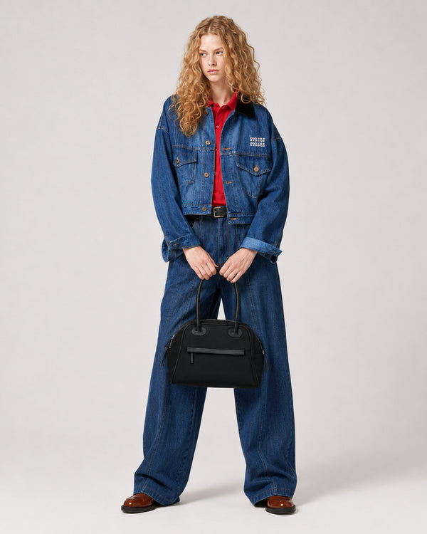 Structured dome top-handle bag in matte nylon with pebbled vegan leather-look trim, zip-top closure, front slip pocket, and