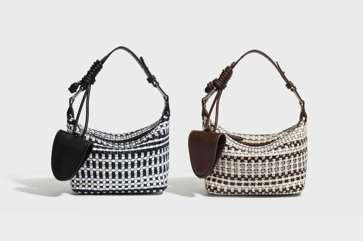 Small crescent shoulder bag in black-and-white woven textile with smooth black leather-look trim, zip-top closure, knotted