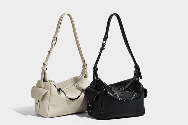 Small slouchy moto-style crossbody bag in smooth matte leather-look finish with white contrast stitching, silver-tone, detail