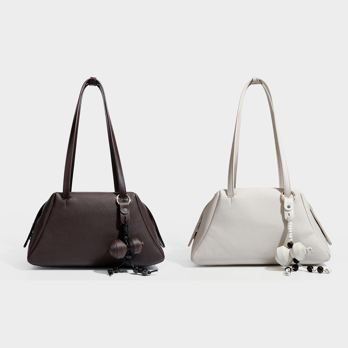 Structured trapezoid shoulder bag in dark brown pebbled leather-look finish with slim double straps, top zip closure, side