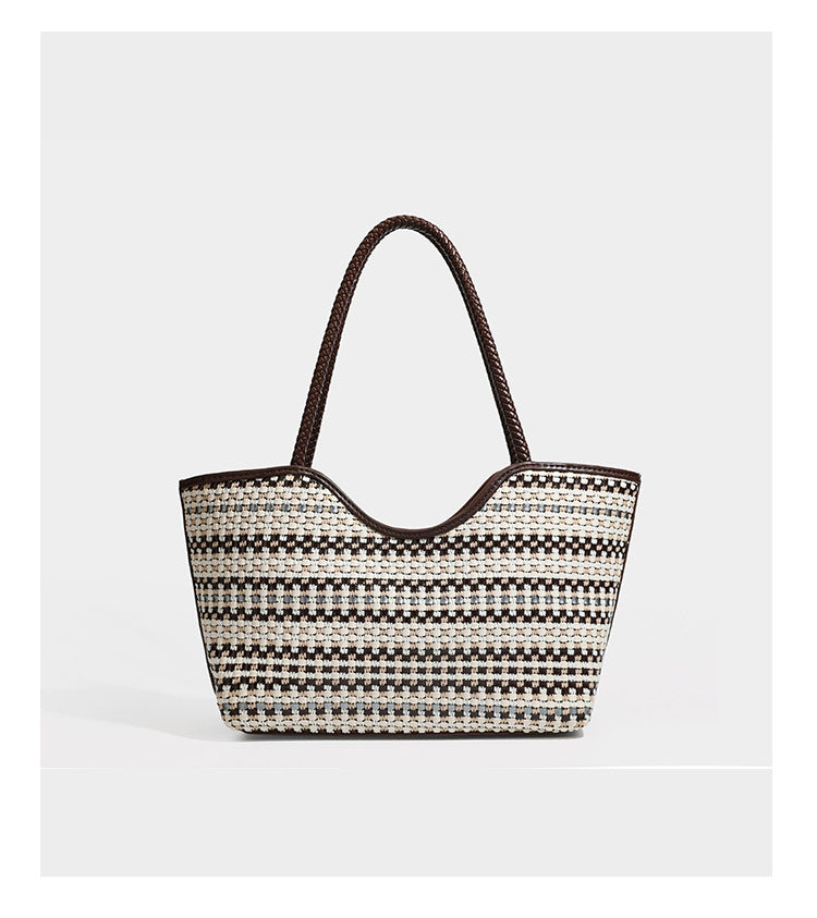Large woven checker-pattern tote bag with dark braided shoulder straps, leather-look trim, and drawstring side ties, detail