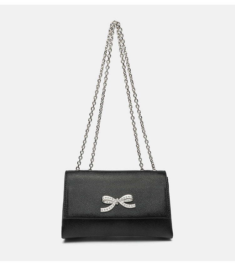 Structured rectangular flap crossbody bag with rhinestone bow and silver chain strap in pebbled finish, detail view 14
