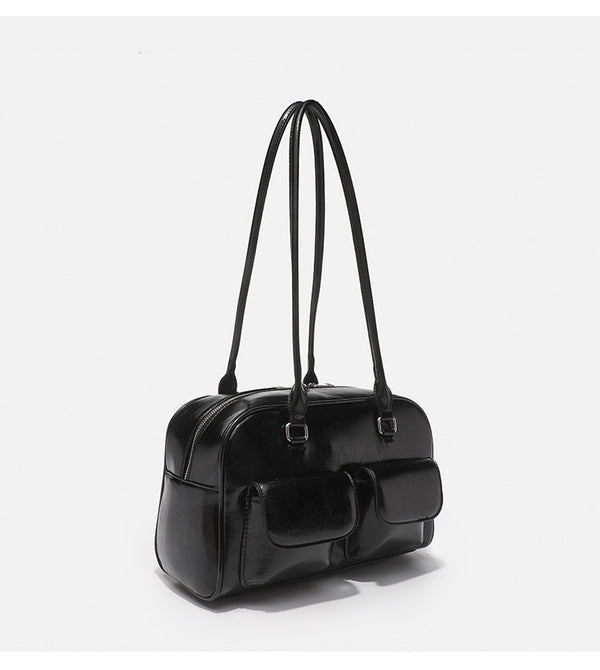 Structured glossy leather-look bowling shoulder bag with two front flap pockets, top zip closure, and long double shoulder