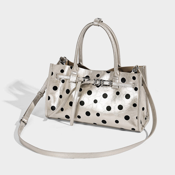 Structured glossy polka-dot tote bag with double top handles and front buckle hardware, detail view 2