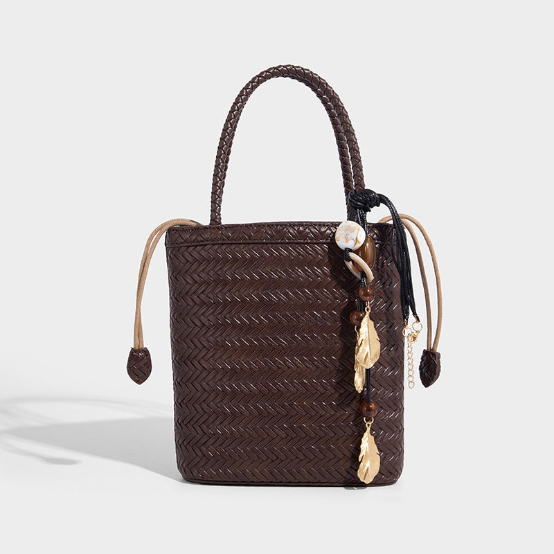Small structured woven-texture tote bag with braided top handles and drawstring inner pouch, detail view 7