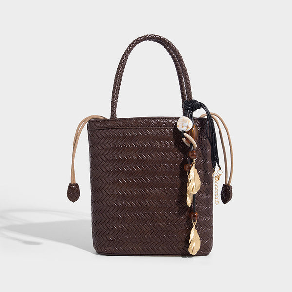 Small structured woven-texture tote bag with braided top handles and drawstring inner pouch, detail view 7