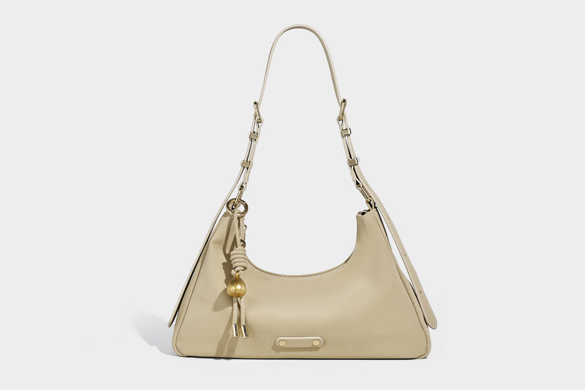Crescent hobo shoulder bag in pebbled leather-look finish with top zipper, adjustable strap, gold-tone ring hardware, and
