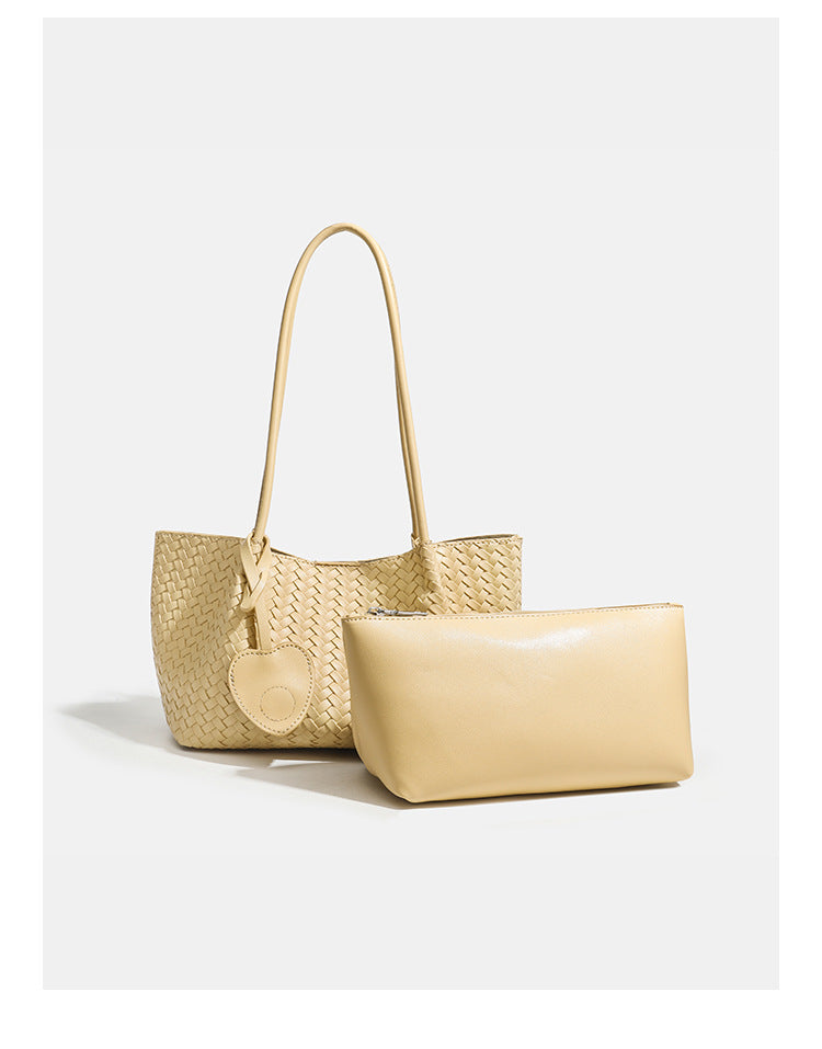 Woven leather-look tote bag in yellow with long shoulder straps, heart-shaped hanging charm, and removable inner zip pouch