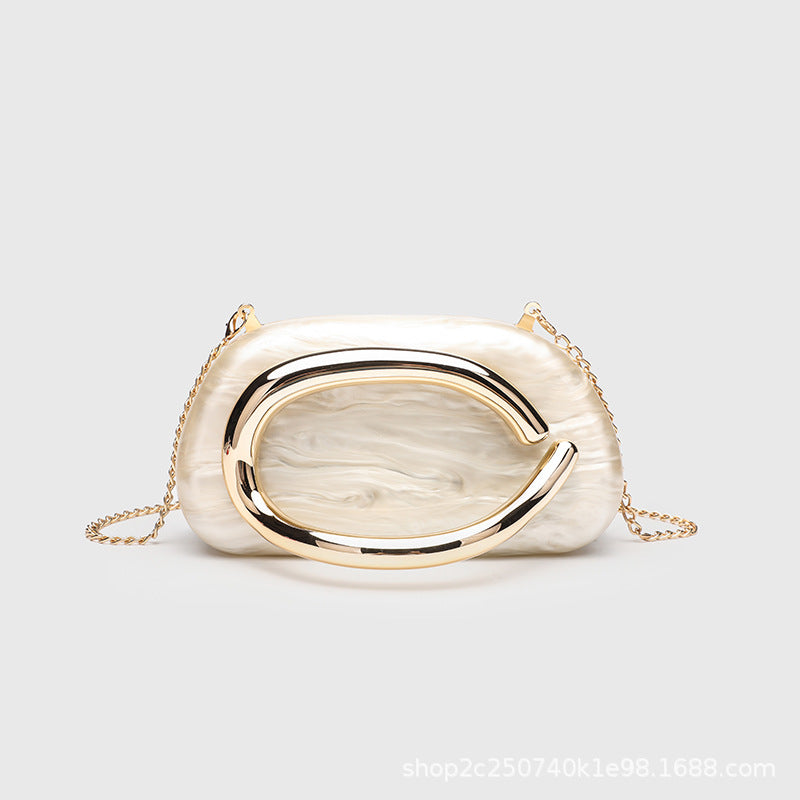 Kleine rechteckige Crossbody-Clutch mit abgerundeten Ecken, oversized poliertem C-förmigem Goldgriff und schmalem Goldkettenriemen, Detailansicht