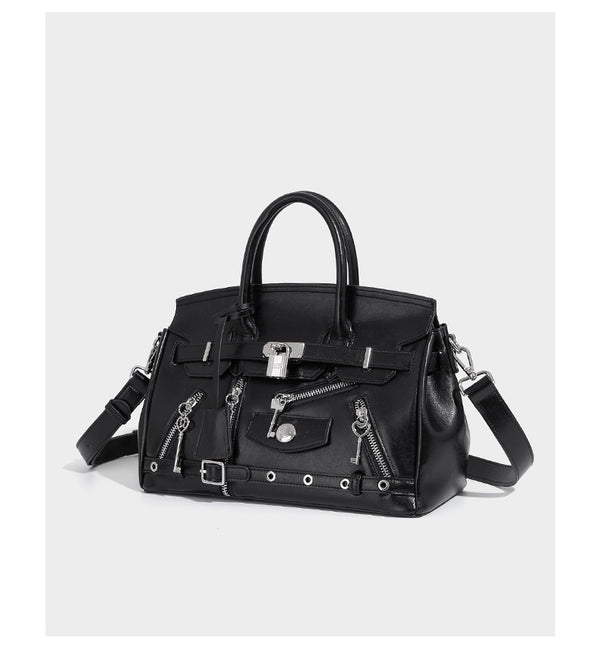 Structured black leather-look satchel bag with silver padlock hardware, front zip pockets, key charms, and top handles