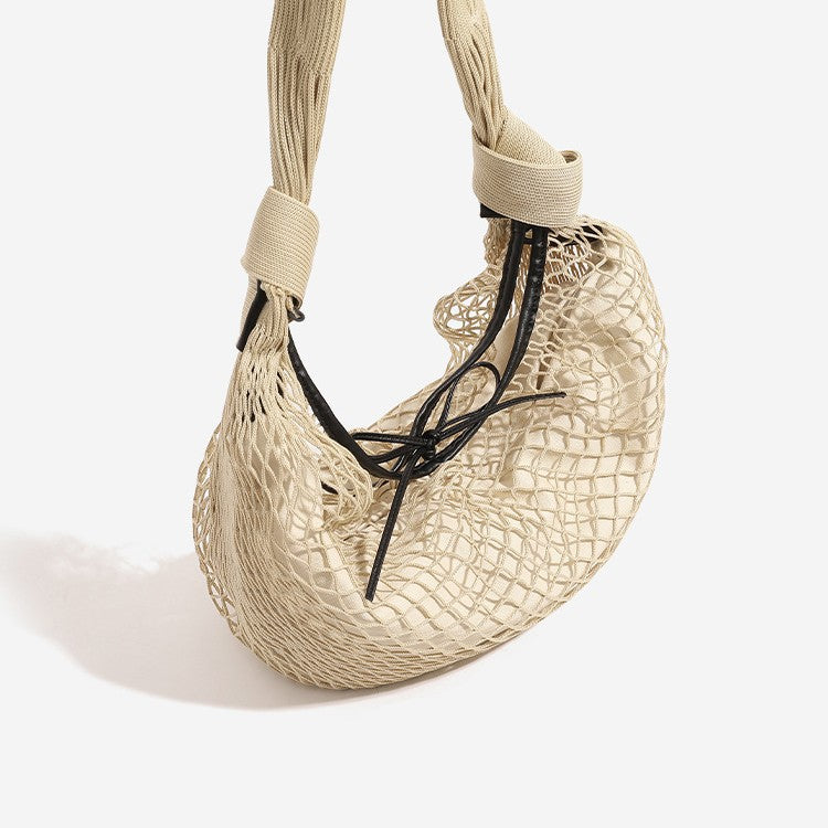 Crescent-shaped open-weave mesh shoulder bag with black drawstring cord tie and long padded strap, front view