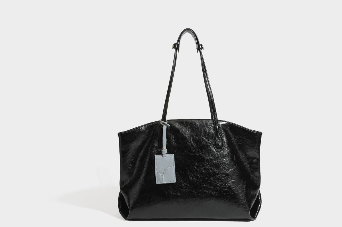 Übergroße, lässig fallende Tote-Bag aus glänzendem, geknittertem Lederimitat in dunklem Burgunderrot mit zwei langen Schulterriemen und kontrastierendem