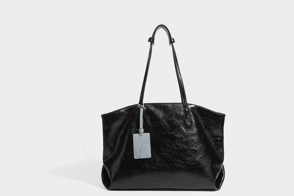 Übergroße, lässig fallende Tote-Bag aus glänzendem, geknittertem Lederimitat in dunklem Burgunderrot mit zwei langen Schulterriemen und kontrastierendem