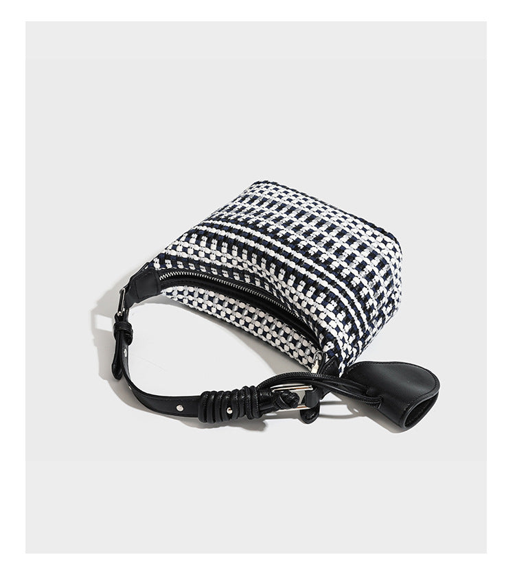 Small crescent shoulder bag in black-and-white woven textile with smooth black leather-look trim, zip-top closure, knotted