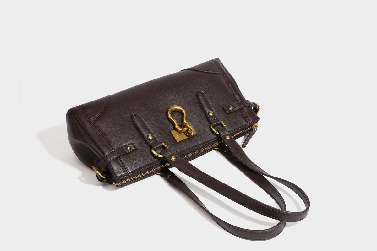 Strukturierte dunkelbraune Satchel-Tote in Lederoptik mit Ringverschluss in Antikgold-Optik, zwei Henkeln und seitlichem Riemen mit Schnalle