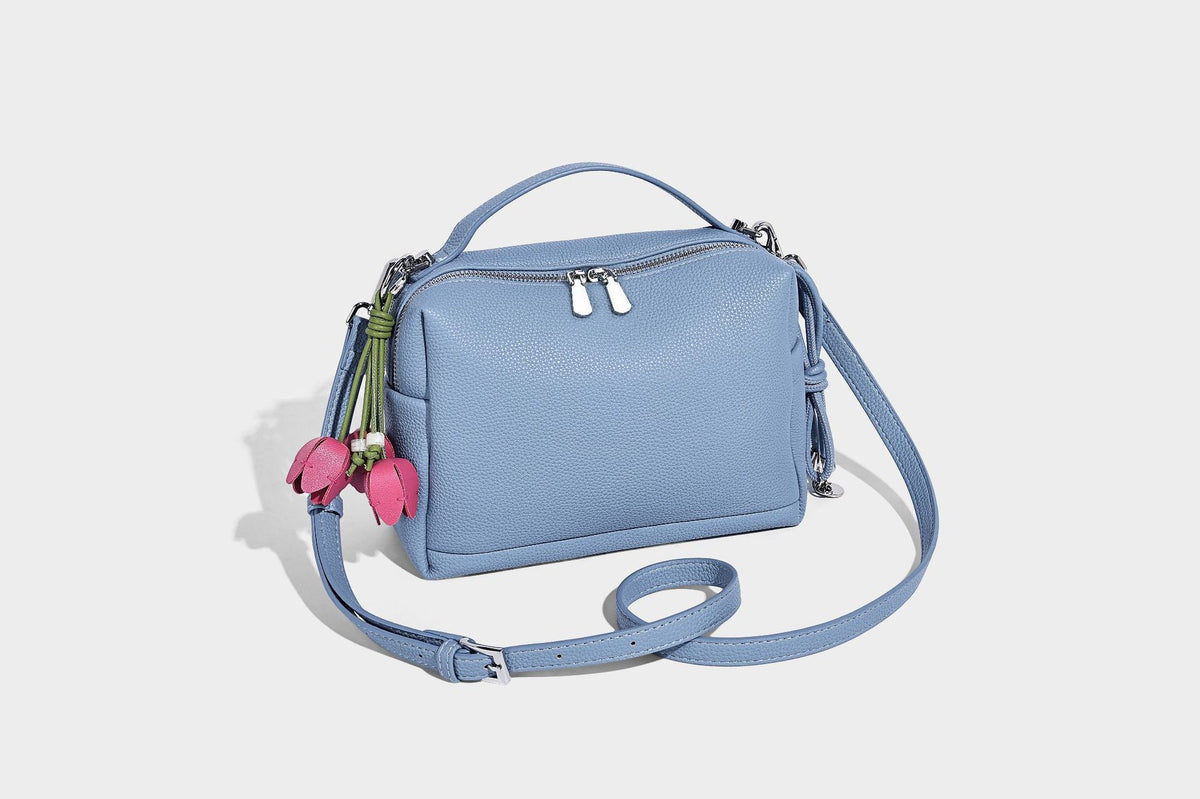 Kleine strukturierte Crossbody-Tasche mit Tragegriff aus genarbtem Material, Reißverschluss, silberfarbenen Beschlägen und optionalem Quastenanhänger