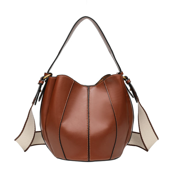Smooth leather-look paneled bucket bag in brown with wide woven shoulder strap, gold-tone ring hardware, and detachable zip