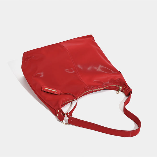 Large red glossy leather-look slouchy hobo shoulder tote bag with zip-top closure and gold-tone hardware, detail view 3