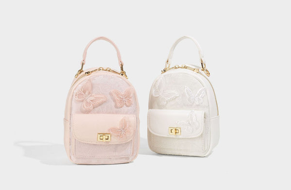 Structured mini backpack handbag with butterfly embroidery, gold-tone chain strap, and turn-lock front flap pocket, detail